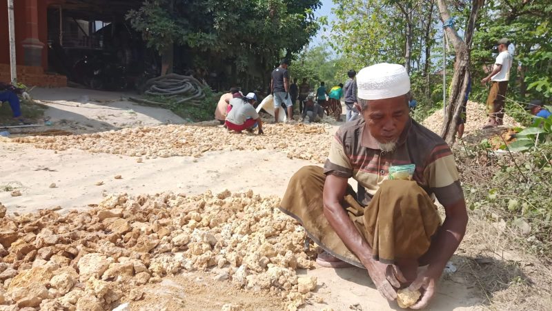Warga Angsanah Pamekasan saat tengah memperbaiki jalan yang rusak.