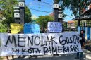 Pemuda dan mahasiswa saat membentangkan sepanduk penolakan Gus Ipul di depan pintu masuk kampus UIN Madura.