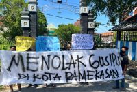 Pemuda dan mahasiswa saat membentangkan sepanduk penolakan Gus Ipul di depan pintu masuk kampus UIN Madura.