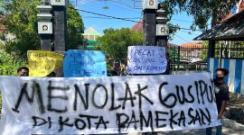 Pemuda dan mahasiswa saat membentangkan sepanduk penolakan Gus Ipul di depan pintu masuk kampus UIN Madura.
