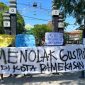 Pemuda dan mahasiswa saat membentangkan sepanduk penolakan Gus Ipul di depan pintu masuk kampus UIN Madura.